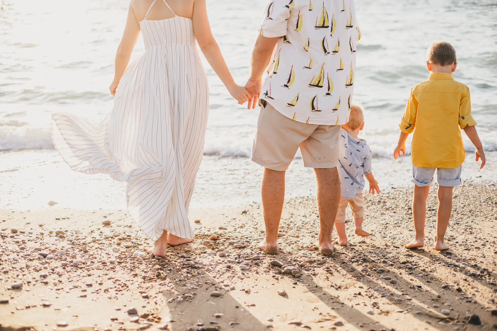 happy-family-having-fun-on-a-beach-at-sunset-2024-12-04-07-14-51-utc